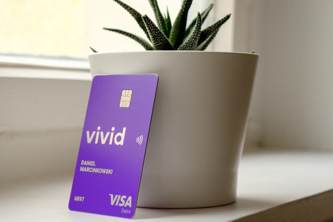 Vivid purple bank card next to a plant
